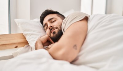 Young hispanic man sleeping on bed at bedroom