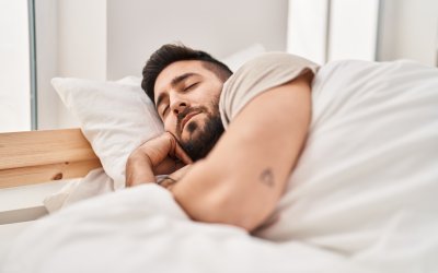 Young hispanic man sleeping on bed at bedroom