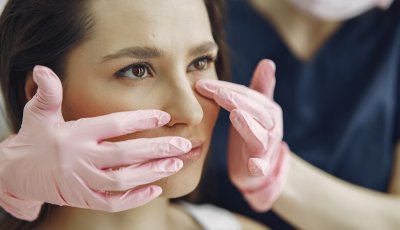 Cosmetologist holds hands near client's face. Woman with cosmetologist. Lady in a beauty studio.