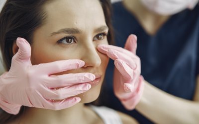 Cosmetologist holds hands near client's face. Woman with cosmetologist. Lady in a beauty studio.