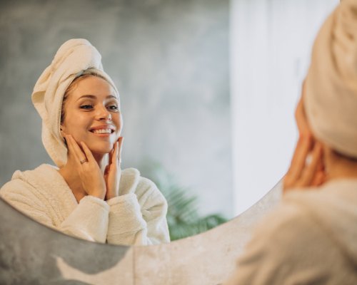 Woman at home applying cream mask