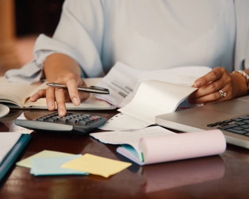 Hands of female entrepreneur working with bills and documents