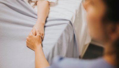 Nurse holding her patients hand