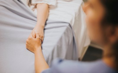 Nurse holding her patients hand