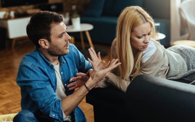 Couple with relationship difficulties having a conflict while talking in the living room.