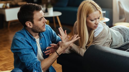 Couple with relationship difficulties having a conflict while talking in the living room.